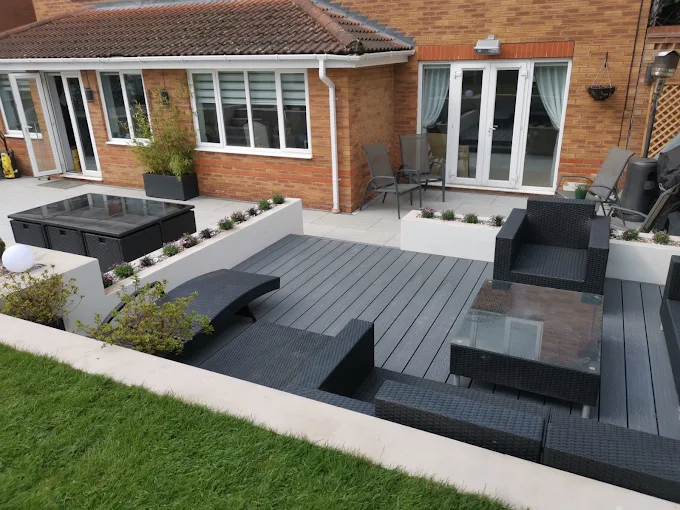 Grey composite decking with rendered raised planters and lawn