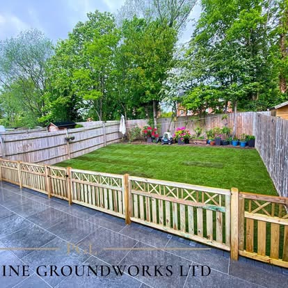 After: dark paved patio with decorative timber fencing and a lawn