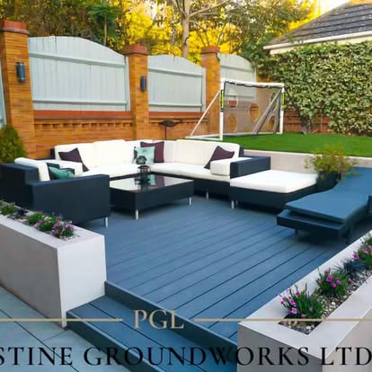 After: grey composite deck with white planters and outdoor sofas