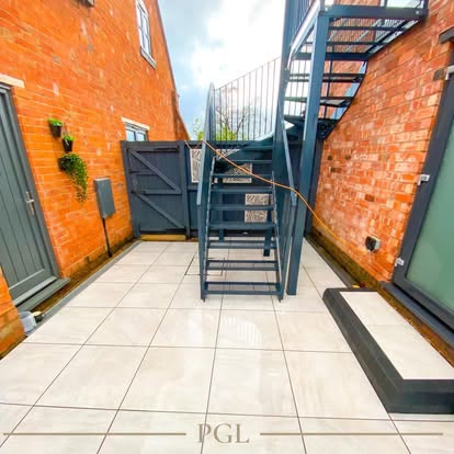 After: porcelain courtyard around a black metal staircase