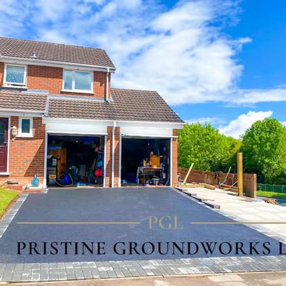 After: large new tarmac driveway in front of a double garage
