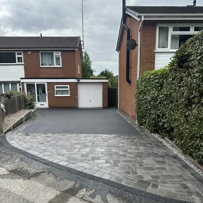 Tarmac driveway with a curved block paved edge beside a tall hedge