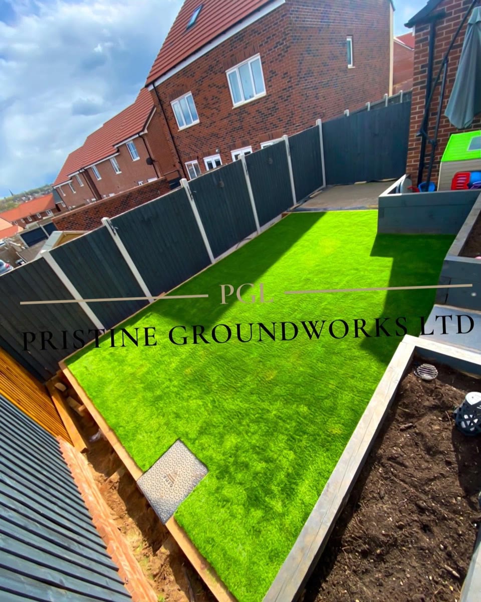 After: artificial grass lawn beside raised beds in a new build garden