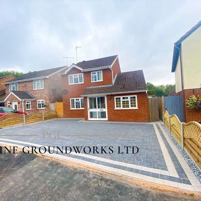 Charcoal block paved driveway with a border outside a detached house