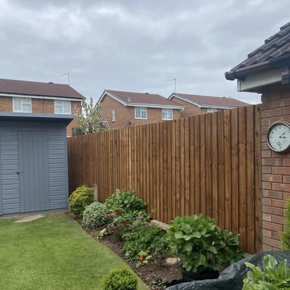 New timber fence beside a lawn and grey shed