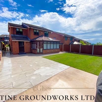 Large porcelain patio and lawn behind a detached house