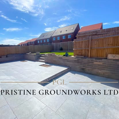 Large porcelain patio with a raised sleeper wall in a new build garden